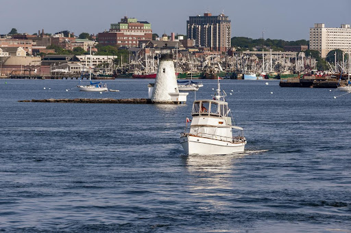 New Bedford, Massachusetts, USA - August 3, 2019: Yacht outbound in New Bedford inner harbor on a summer morning